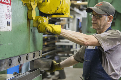 A man at AGET Manufacturing in Michigan runs a machine