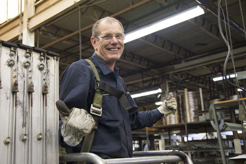 Michigan manufacturing worker smiles and gives thumbs up
