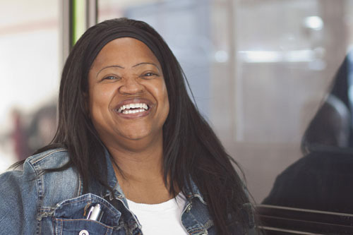 Woman smiles in the Jackson Michigan Transit Authority office for a website photo