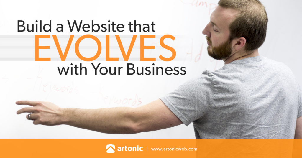 Man points to whiteboard where he's written build a website that evolves