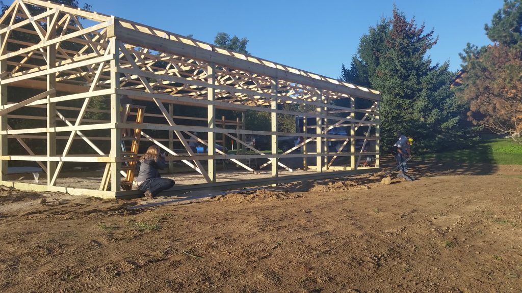 Woman photographs barn.