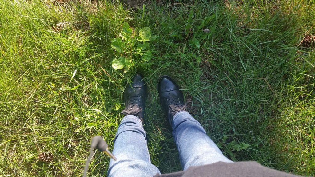 Woman's booted feet in grass.