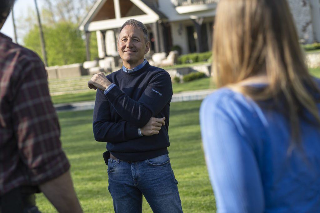 Photo of man in a blue sweater and jeans.